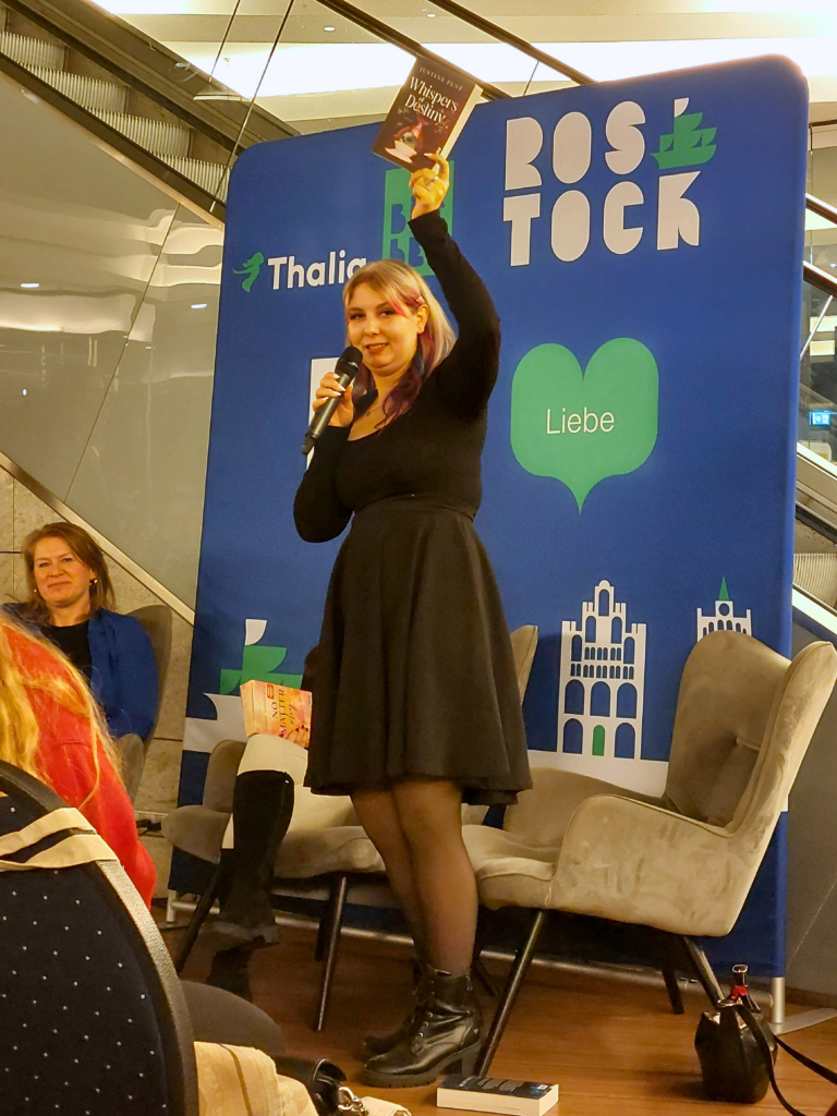 Justine Pust versteigert ihr Buch "Whispers of Destiny".