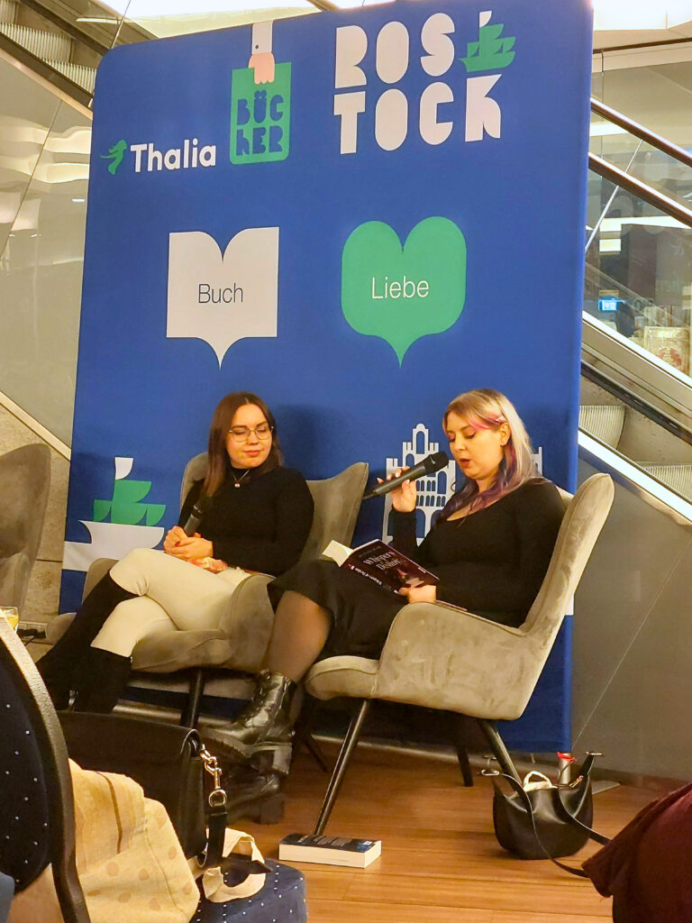 Justine Pust liest aus ihrem Buch "Whispers of Destiny" und Sarah Stankewitz hört zu.